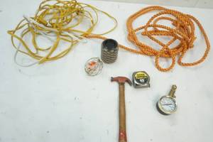 lot 29 image: Tire Pressure gauge, rope, tape measure, 2 cat toys, 2 small extension cords