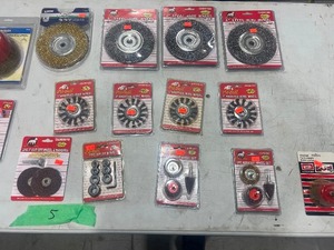 Table full of wire wheels, brushes, and wood carving disks