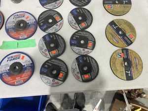 Table full of metal grinding disks 7 inch and 6 inch