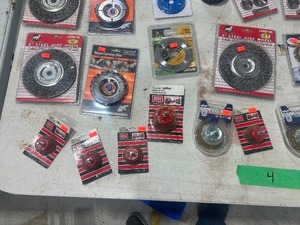 Table full of wire wheels, brushes, and wood carving disks
