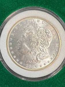 lot 95 image: 1886 US MORGAN SILVER DOLLAR IN GREEN CASE