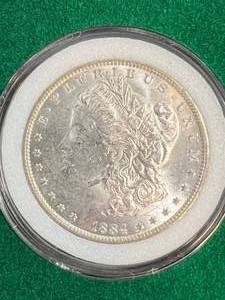 lot 97 image: 1884-O US MORGAN SILVER DOLLAR IN GREEN CASE