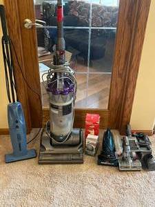 lot 156 image: 3 Vacuums - 1 Dyson, Eureka Stick Vac, Hoover Hand Vac, Misc. Parts for Dyson HandheldStick, Lint Removers - all untested