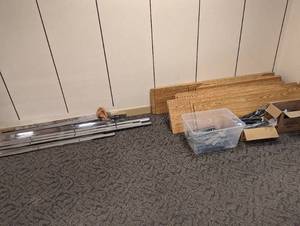 Metal framed shelving unit with assorted length coated Melanine Board shelving planks and metal brackets