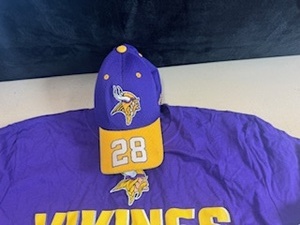 lot 32 image: Minnesota Vikings - Adrian Peterson Hat and Vikings Football T-Shirt (new with tags)