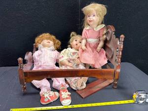 lot 1497 image: WOOD DOLL BED WITH 3 PORCELAIN DOLLS
