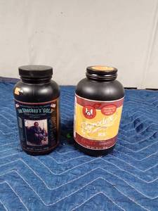 lot 271 image: Bottle of 45 cal. pressed black powder charges and a bottle of black powder
