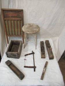 lot 65 image: Vintage lot of primitive pieces. Milking stool, wood box, planes, saw, wash board.