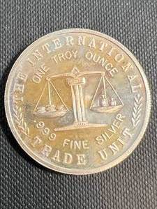 lot 53 image: 1 TROY OZ .999 FINE SILVER INTERNATIONAL TRADE UNIT ROUND
