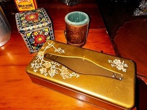lot 190 image: Vintage Ransburg Gold Rectangular Tissue Holder, Box of Marbles, and Leather Dice Shaker