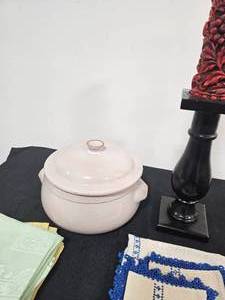 lot 270 image: Pedestal Candle Holder with Red Candle, Various Cloth Napkins (Yellow, Sea Foam Green and White w Blue), Pink Emile Henry France Cookware w Lid