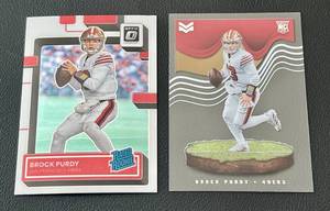 lot 29C image: Lot of 2 Brock Purdy Rookie Cards - 2022 Donruss Optic RR Base #277 22 Chronicles RC Clear # MAG-27 - Football Cards
