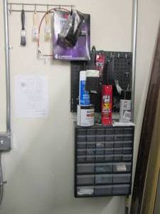 Multi-drawer hardware organizer with content, pegboard with hooks and supplies shown