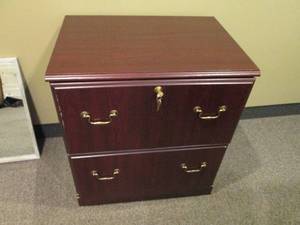 2-drawer Lateral file cabinet in a woodgrain finish with brass tone hardware and keys