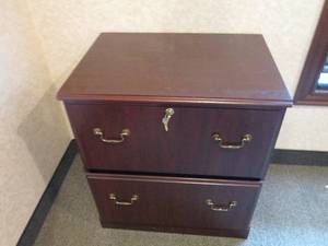 2-drawer Lateral file cabinet in a woodgrain finish with brass tone hardware with keys