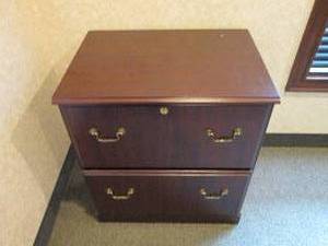 2-drawer Lateral file cabinet in a woodgrain finish with brass tone hardware