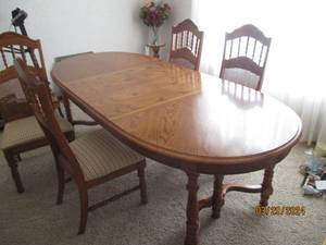 lot 3 image: Well made wood Dining table with (4) padded chairs featuring spindle and Wicker Rattan lattice style carved detail high backs