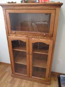 lot 99 image: Uniquely designed Wood cabinet with lateral style upper encasement, cupboard style Dual doors with 3-tiers to display your treasures shown through its glass fronts