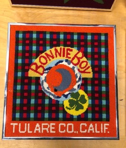lot 127 image: 3 Framed Needlepoint Folk Art Pieces - Old Advertising Crate Labels