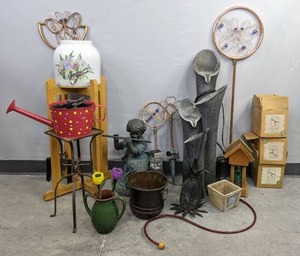 lot 73A image: Planter, Plant Stand, Watering Can, Flower Porcelain Water Dispenser, Handblown Glass Hummingbird Feeders, ButterflyFlowerDragonfly Rotating Decorative Garden Sprinklers, Boy Playing Flute Yard Statue and More H
