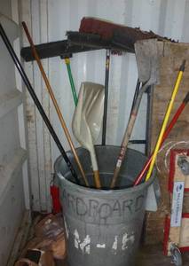 Garbage pail full of brooms
