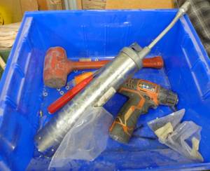 Blue bin with grease gun, hammer, drill
