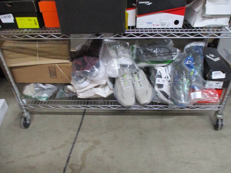 lot 733 image: Rack of over 50 pairs of authentic name brand shoes - these shoes were bought from big box retail stores and outlets.  Some may have signs of wear and blemishes. Low reserve of 750.00