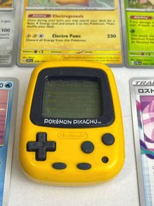 lot 114 image: 1998 Nintendo Pocket Pikachu Pedometer with Assorted Pokemon Trading Cards