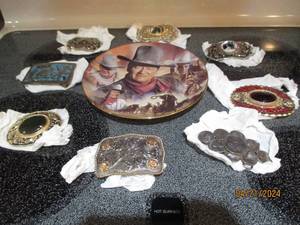 lot 37 image: Hand painted John Wayne Wall plate amongst a collection of detailed belt buckles