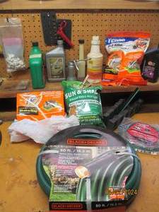 lot 106 image: Collection of garage and outdoor supplies including 50ft heavy duty garden hose, grass seed, ant killer, automotive oils, zip ties and more