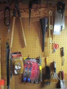 lot 110 image: Wall content including a variety of saws, gardening tools, lopper, ratchet straps and more