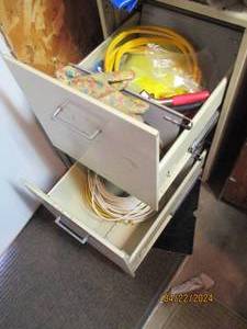 lot 113 image: Standard size 2-drawer file cabinet with content to include jumper cables, extension cords and other supplies