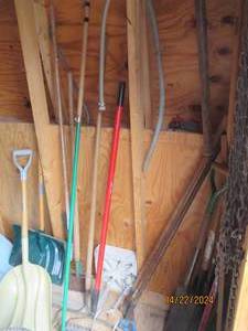 lot 180 image: Corner lot to include a variety of shovels, rakes, hoes, landscape blocks and an axe.