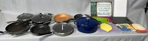 Various Pans (not all have lids), Dutch Oven and Various Cutting Boards and Hot Plates (variety of sizes and colors)