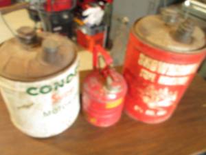 Trio if vintage metal gas cans in a...