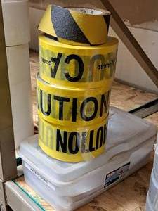lot 509 image: (3) Rolls of CAUTION Tape, Tote w Microbial HAZARD Signs, Partial Roll of CAUTION Grip Tape