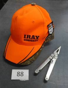 lot 88 image: Camo and Blaze orange hat and a Leatherman Wave multi tool