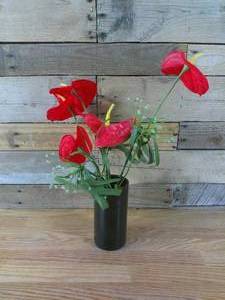lot 128 image: 7 x 3 12 Round Black Vase and Plastic Anthurium Flowers