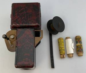 lot 105 image: 1930s Tin Toy Movie Projector With Films Huckleberry Finn, A Tale Of Two Cities & The Son Of Tarzan (Missing Cord)