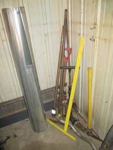 lot 179 image: Corner lot of goodies including duct tubing, pitch fork, carpenters square, pick axe and more