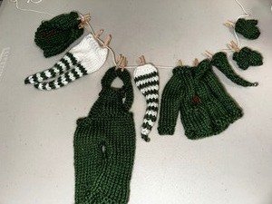 lot 382 image: Adorable Hand Knit Clothing On Clothes Line For Decorations