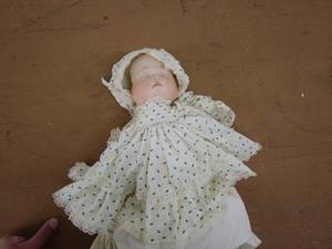 lot 220 image: Antique Porcelain Baby Doll with Polka Dot Dress and Bonnet