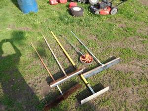 lot 6 image: Concrete rake and brooms and rolling tape measure