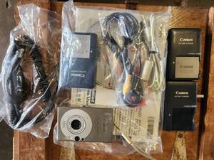 lot 195 image: Canon PowerShot SD1000 Digital Elph 7.1MP Digital Camera with Accessories - (3) Batteries, (3) Chargers, (1) Car Charger