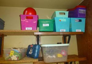 lot 821 image: shelf contents - bins with various toys, chalk etc