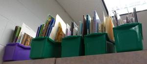 lot 915 image: All the books in plastic totes on top of cabinet and other items