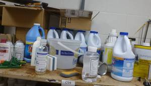 lot C59 image: A bunch of cleaning supplies, bleach, chalkboard cleaner, hand soap, floor wax