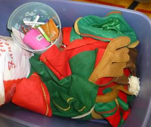 lot G106 image: Tote of Reindeer hats, elf vests and a container with 2 ironman style suits