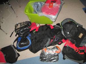lot C313 image: Covered tote overflowing with new back packs and other bags