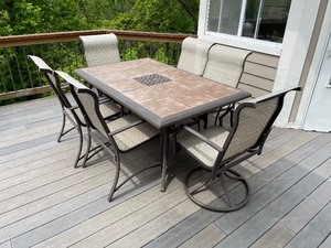 lot 83 image: Tile-Top Metal Patio Table And Six Chairs (Two Chairs Rock). Includes Umbrella Stand. Table Measures 65 Inches Long By 41 12 Inches Wide. Chairs Measure 40 Inches Tall By 22 12 Inches Wide By 28 Inches Deep